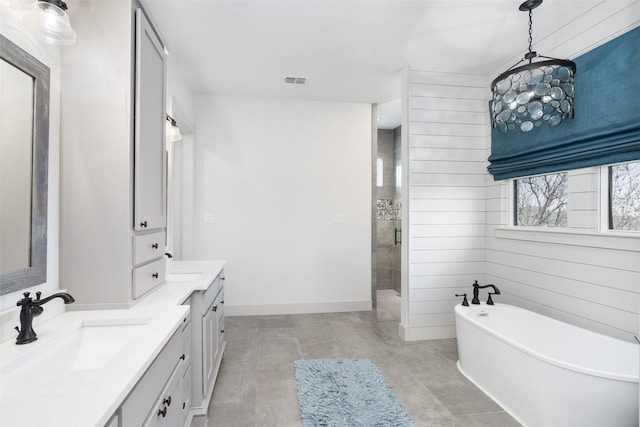 3200 W Fm 455, Celina, TX 75009 - bathroom featuring double vanity, visible vents, a freestanding tub, a shower stall, and a sink