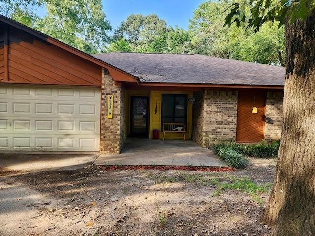 view of front of property featuring driveway, brick siding, and an attached garage