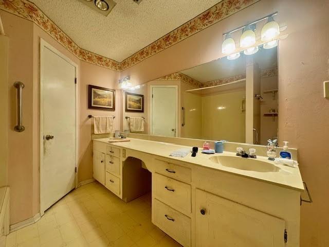 23319 Penninsula Pt, Frankston, TX 75763 - full bathroom featuring double vanity, tile patterned floors, a textured ceiling, and a shower