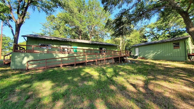 back of property featuring a wooden deck and a yard