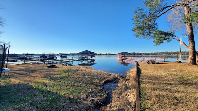 dock area with a water view and a lawn