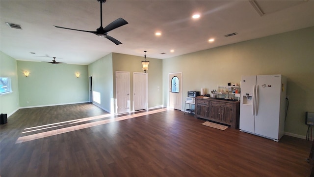 interior space featuring open floor plan, white refrigerator with ice dispenser, dark wood-style floors, and visible vents