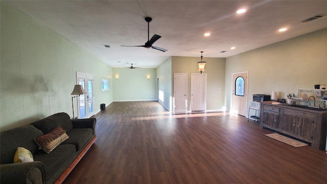 living area featuring baseboards, dark wood-style flooring, visible vents, and a ceiling fan