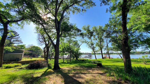 view of property's community featuring fence, a water view, and a yard