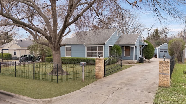 view of front of home featuring a fenced front yard, roof with shingles, a front lawn, and an outbuilding