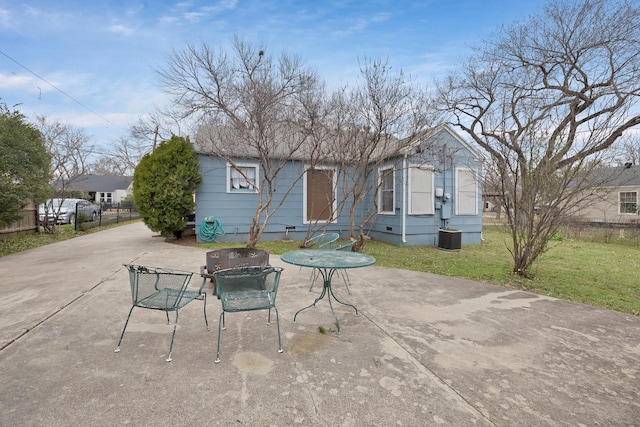 back of property with outdoor dining space, a patio, driveway, and fence