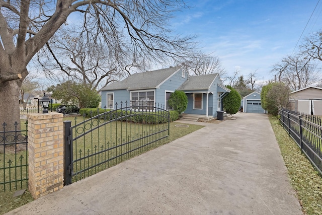 bungalow-style house with a fenced front yard, an outbuilding, a detached garage, a shingled roof, and a front lawn