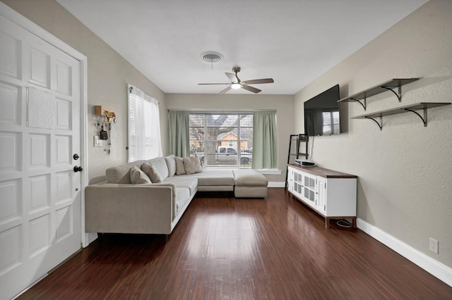 unfurnished living room with ceiling fan, baseboards, visible vents, and dark wood finished floors