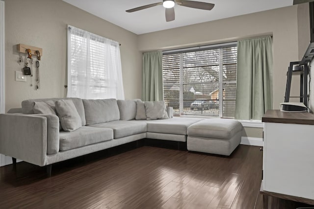 living area with dark wood-style flooring, ceiling fan, and baseboards