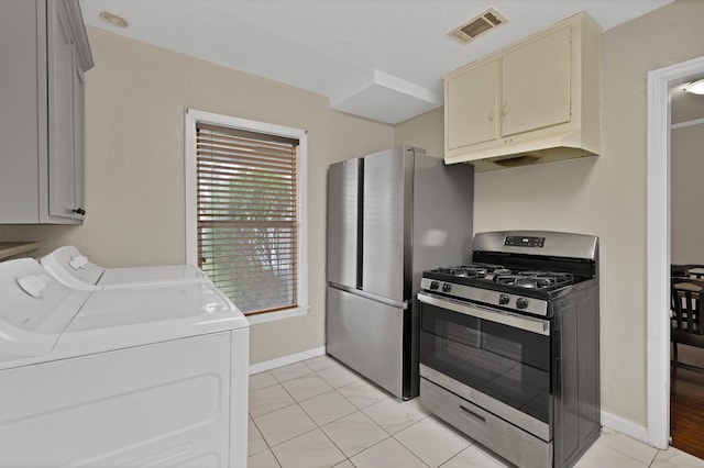 kitchen with light countertops, visible vents, appliances with stainless steel finishes, washer and dryer, and baseboards