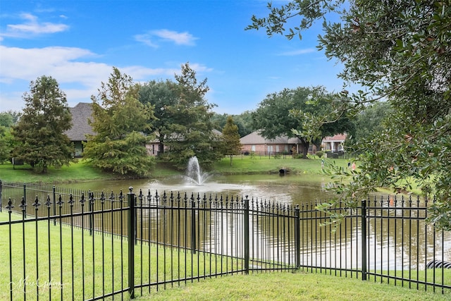 exterior space with a lawn, fence, and a water view