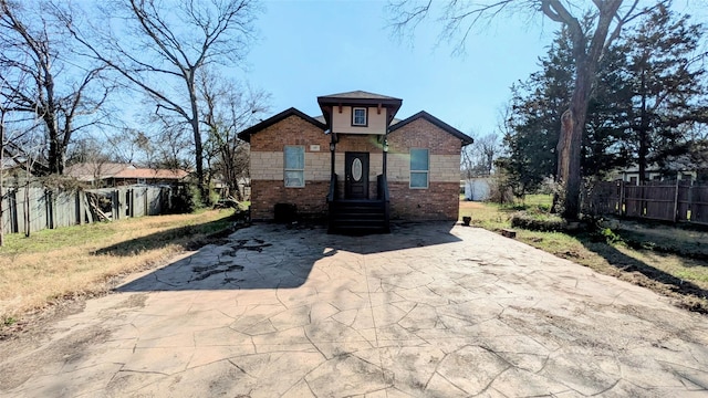 bungalow-style home featuring a patio area, brick siding, and fence