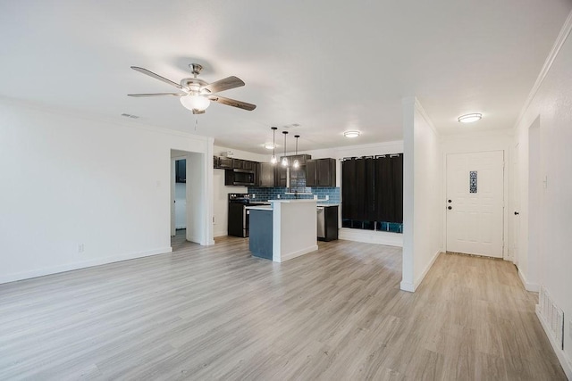 kitchen featuring light countertops, open floor plan, a kitchen island, dark brown cabinetry, and range with electric cooktop