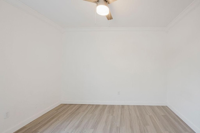 empty room with crown molding, light wood-style flooring, and baseboards