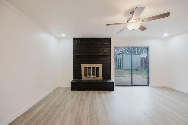 unfurnished living room featuring recessed lighting, light wood-style floors, a ceiling fan, a brick fireplace, and baseboards