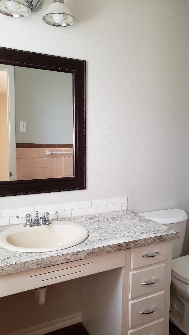 3304 Avon Dr, Denton, TX 76209 - bathroom featuring toilet, vanity, and backsplash