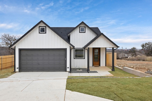 modern inspired farmhouse with an attached garage, a shingled roof, fence, concrete driveway, and a front yard