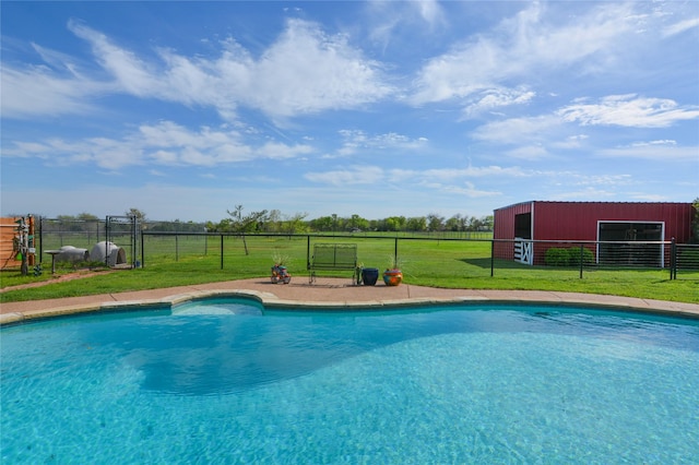 view of swimming pool with an outbuilding, an outdoor structure, fence, a lawn, and a fenced in pool