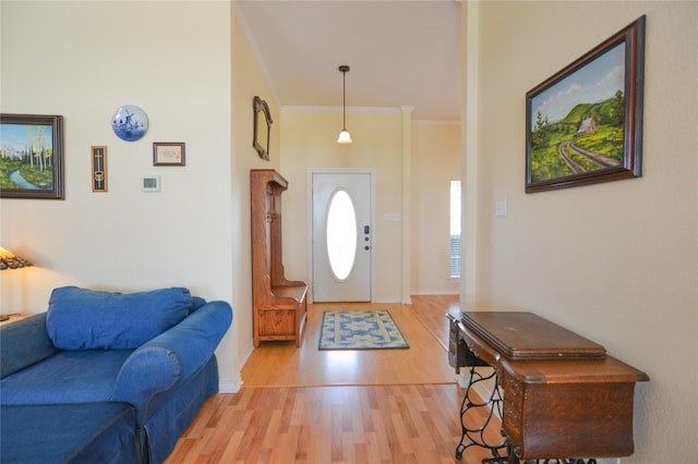 foyer entrance with baseboards, light wood-style flooring, and crown molding