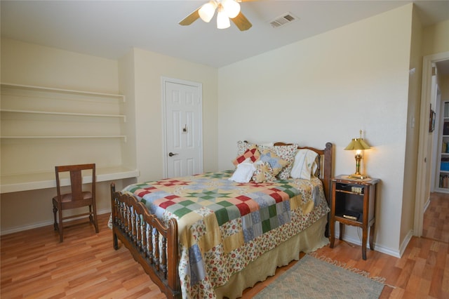 bedroom with ceiling fan, wood finished floors, visible vents, and baseboards