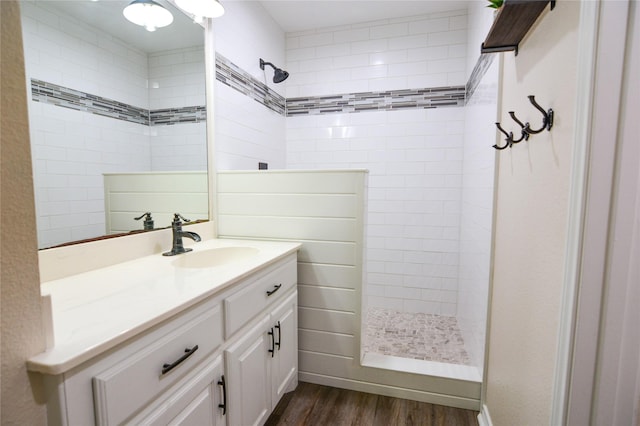 full bathroom featuring wood finished floors, vanity, and walk in shower