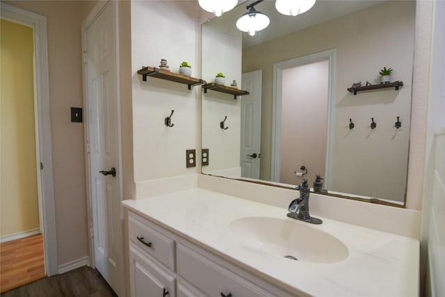 bathroom featuring baseboards, wood finished floors, and vanity