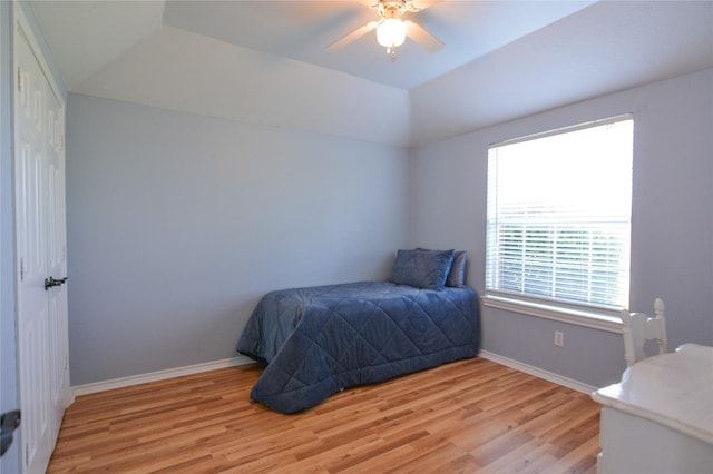 bedroom with lofted ceiling, ceiling fan, light wood-style flooring, and baseboards