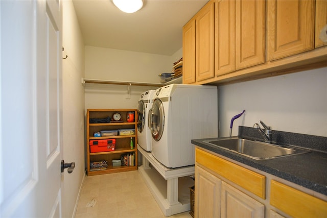 washroom featuring light floors, washing machine and clothes dryer, a sink, and cabinet space