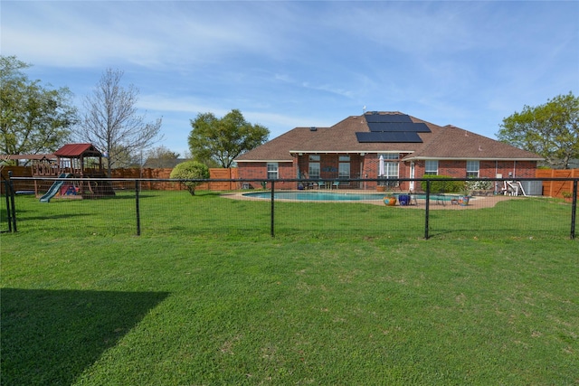 view of yard with a fenced in pool, playground community, and a fenced backyard