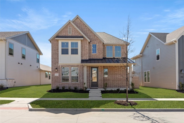 view of front of house featuring metal roof, brick siding, a standing seam roof, and a front yard