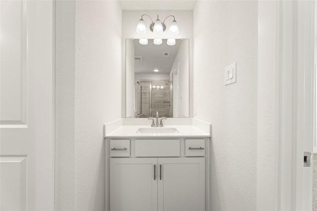 bathroom featuring visible vents, a shower stall, and vanity