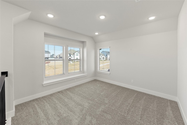 carpeted empty room with recessed lighting, vaulted ceiling, and baseboards