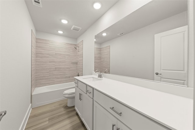 full bath featuring visible vents, vanity, toilet, and wood finished floors