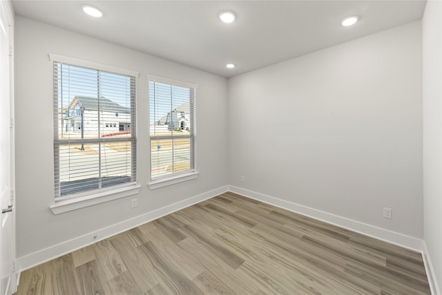 unfurnished room with light wood-style flooring, baseboards, and recessed lighting