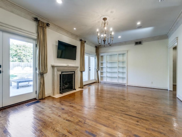 unfurnished living room with plenty of natural light, a premium fireplace, visible vents, and crown molding