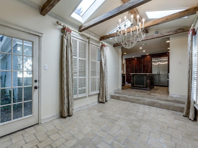 unfurnished living room featuring lofted ceiling with skylight, baseboards, and an inviting chandelier