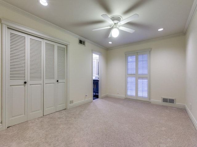 unfurnished bedroom featuring visible vents, light colored carpet, and ornamental molding