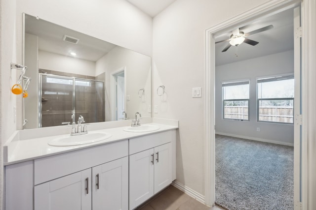 full bath with visible vents, a sink, a shower stall, and double vanity