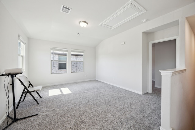 unfurnished room featuring carpet floors, baseboards, visible vents, and lofted ceiling