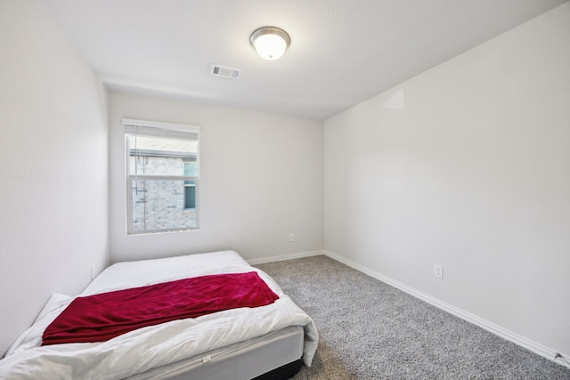 carpeted bedroom with visible vents and baseboards