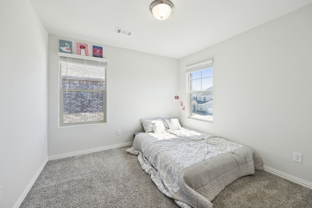 carpeted bedroom with visible vents and baseboards