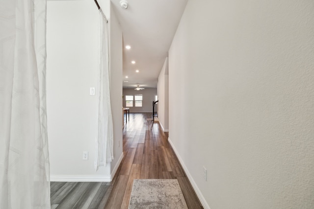 hall featuring recessed lighting, wood finished floors, and baseboards