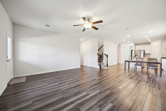 interior space with recessed lighting, visible vents, stairway, wood finished floors, and baseboards