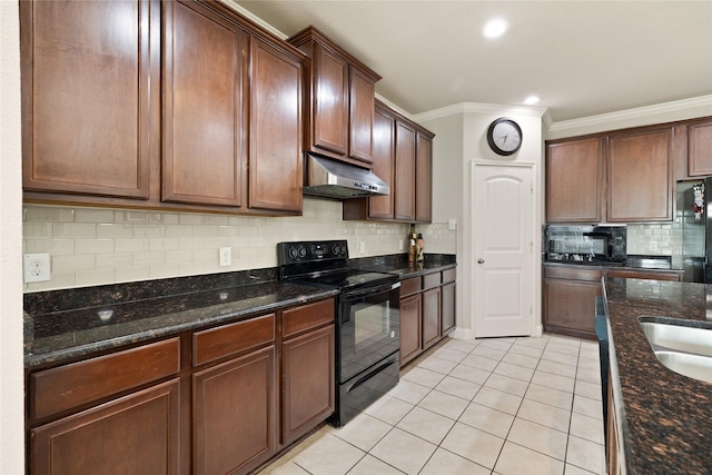 kitchen featuring crown molding, light tile patterned flooring, dark stone counters, under cabinet range hood, and black appliances