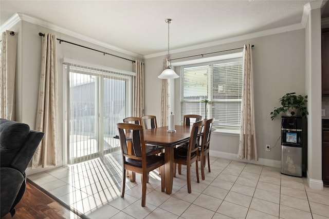 dining space featuring ornamental molding, a healthy amount of sunlight, baseboards, and light tile patterned floors