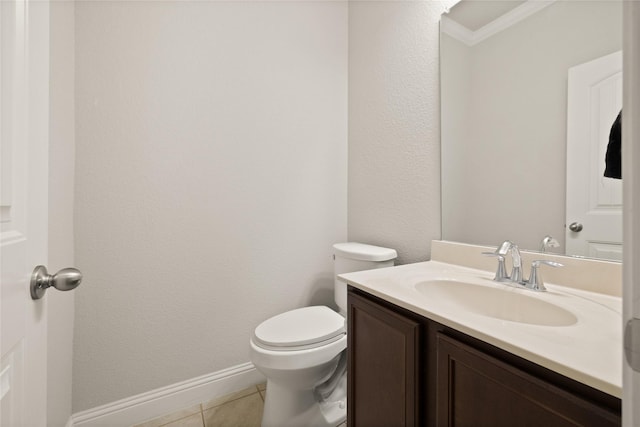 bathroom with toilet, ornamental molding, vanity, baseboards, and tile patterned floors