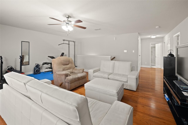 living area featuring ceiling fan, wood finished floors, and baseboards