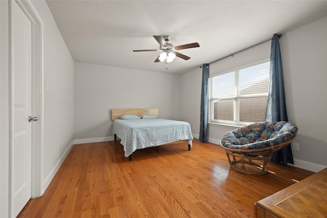 bedroom featuring light wood-style flooring, baseboards, and ceiling fan