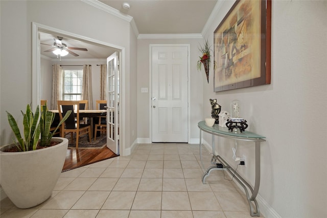 entryway with ceiling fan, crown molding, baseboards, and light tile patterned floors