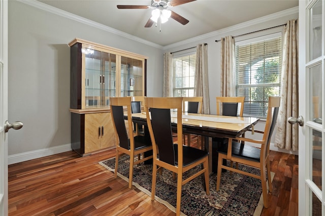 dining room with baseboards, wood finished floors, a ceiling fan, and crown molding